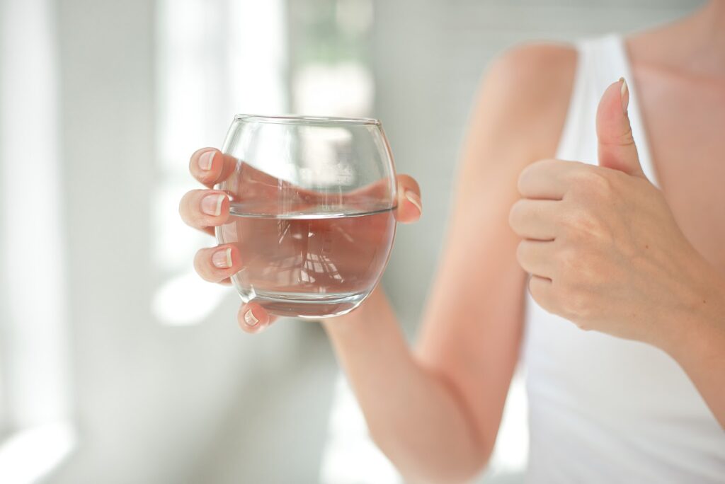 woman holding glass of fresh water - Aquafeel System concept image